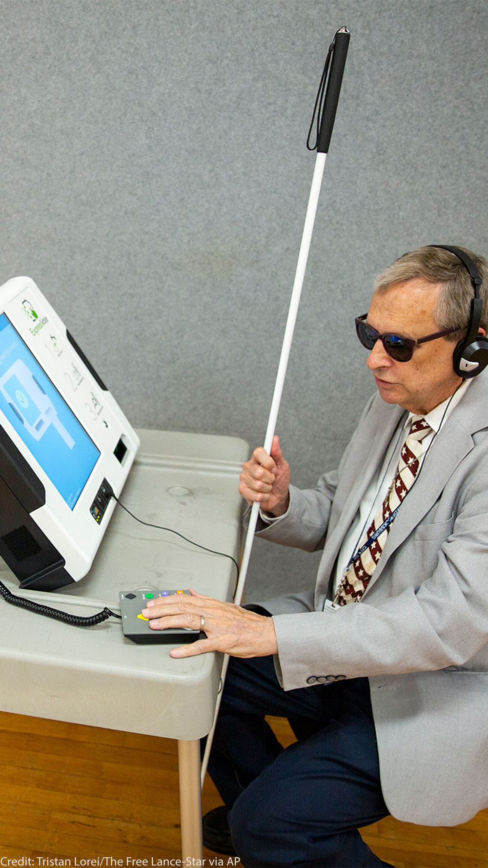 Michael Kasey, who is blind, demonstrates a voting machine that allows people with disabilities to vote.