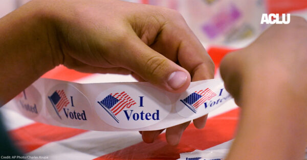 A volunteer prepares "I Voted" stickers at a polling station.