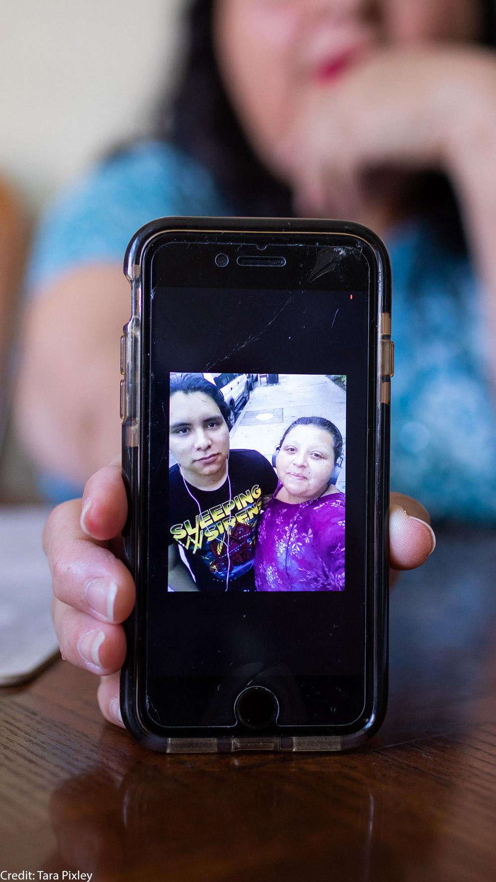 Celia Banos holding a photo of Jhean.