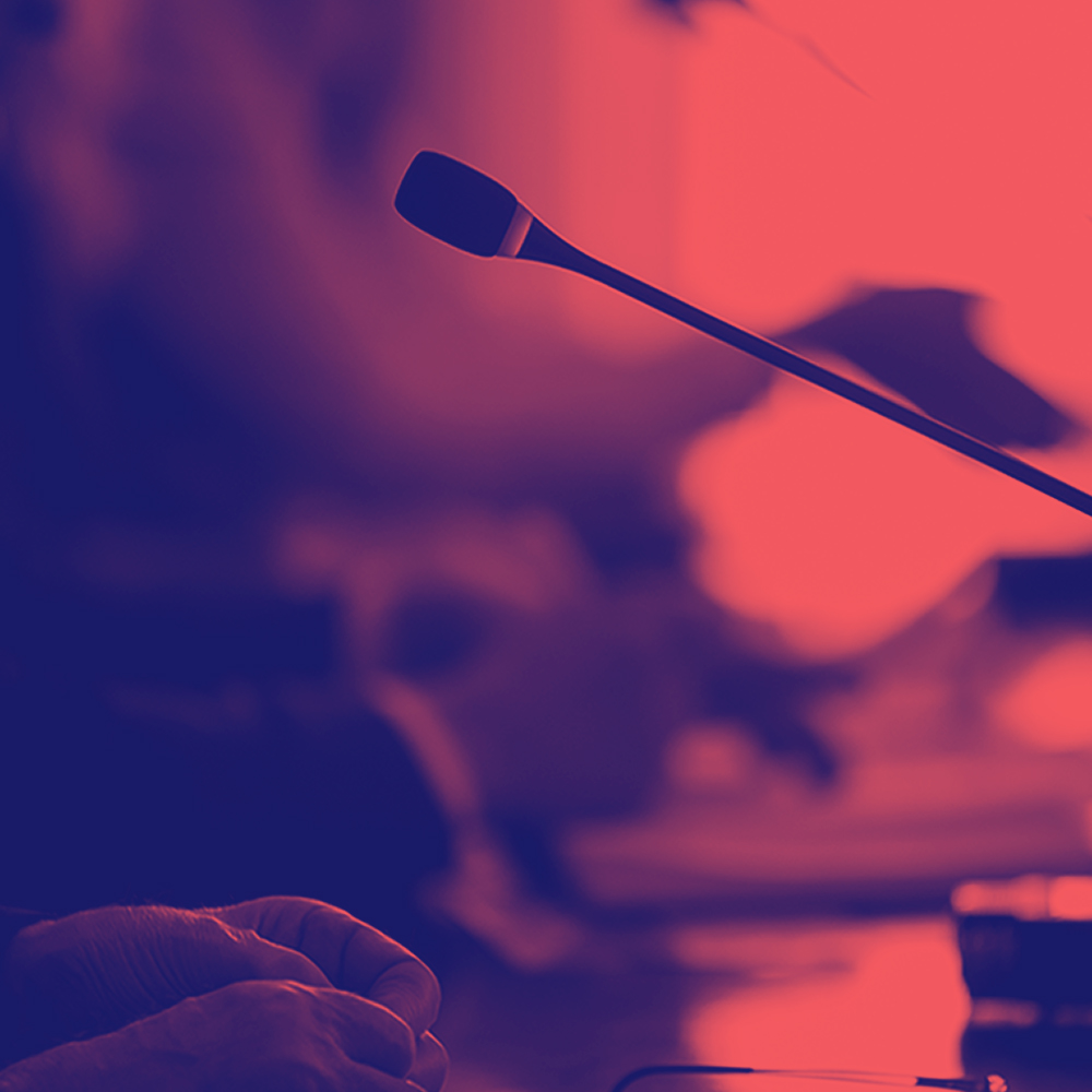 red photo of a person sitting in front of a mic
