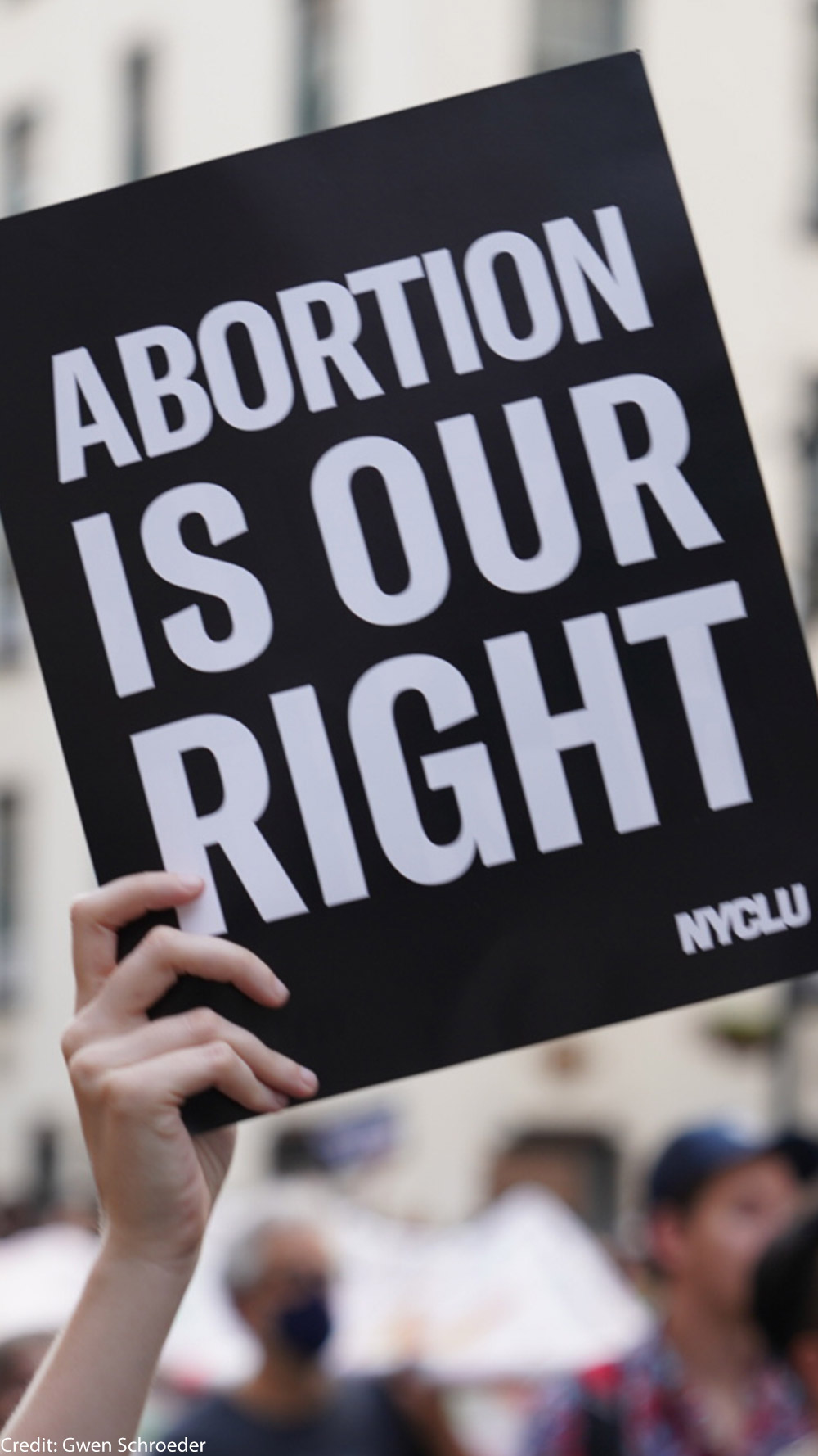 A person holding up a sign saying "Abortion is Our Right."