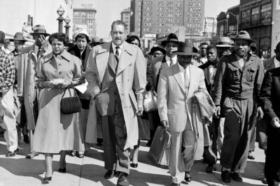 Autherine Lucy, left, front, 26-year-old student at the University of Alabama, arrives at U.S. District Court for the hearing of her petition for an order requiring the school to re-admit her to classes in Birmingham, Ala., Feb. 29, 1956. With Lucy are her legal team, Thurgood Marshall, tall man at center, and Arthur Shores, carrying coat at right.