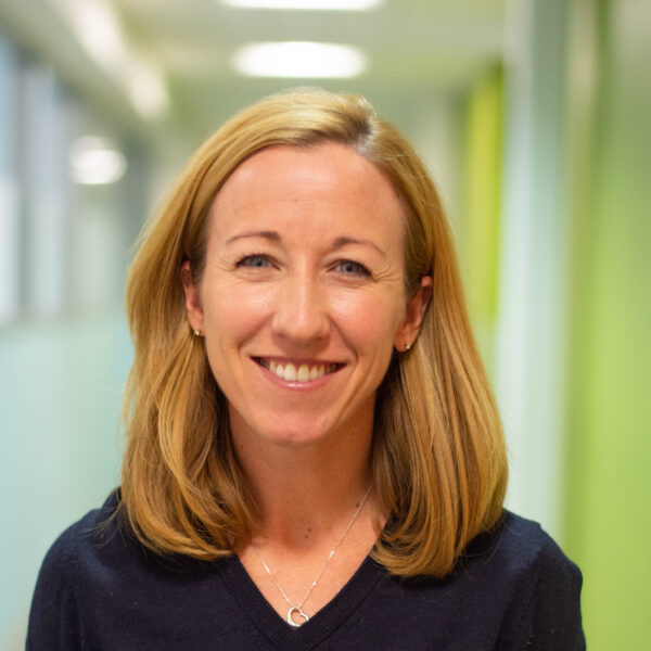 Headshot of Dr. Kate Arnold smiling. She is wearing black medical scrubs.