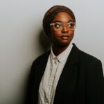 Headshot of Oklahoma State Representative Mauree Turner with a neutral expression. They are wearing a scarf on their head, a black blazer, and a white button-down shirt.