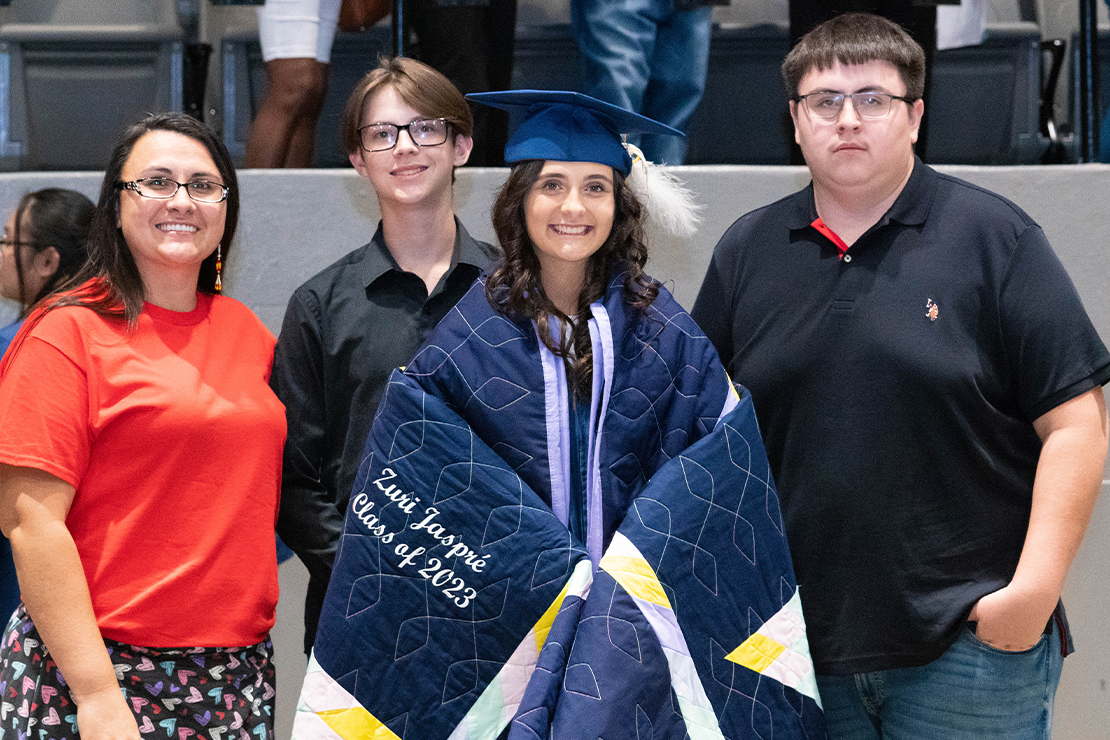 Zuri Wilson is surrounded by her mother and brothers (Carmyne on the left and Jaikan on the right) after being wrapped in her star quilt.