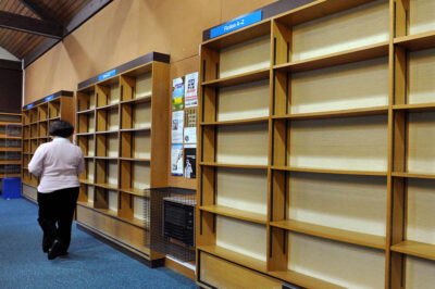 Library protest.A person walks past empty shelves at the library in Stony Stratford, near Milton Keynes, after residents have spent the week withdrawing their maximum allowance of books to stop the council's plans to close it as part of budget cuts.