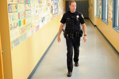 In this Dec. 17, 2012 photo, Officer Rick Moore of the Oakland school district police patrols Oakland Technical High School in Oakland, Calif.