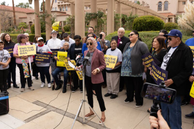 A woman speaking at a rally for asylum.