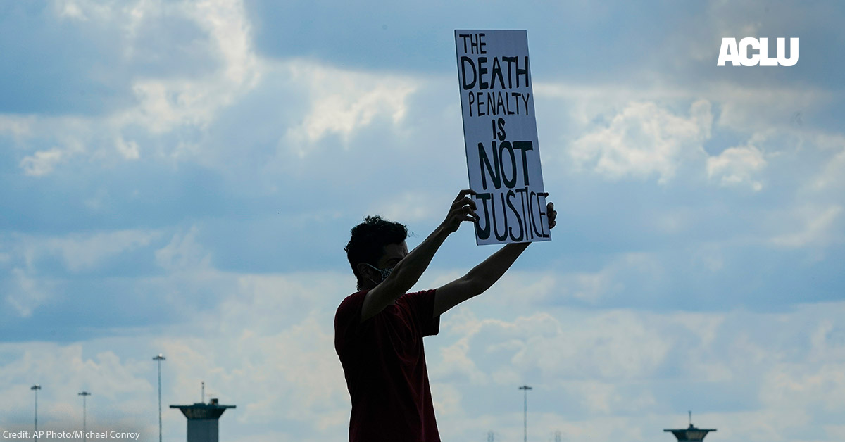 A man holding a sign that says "Death Penalty is Not Justice."