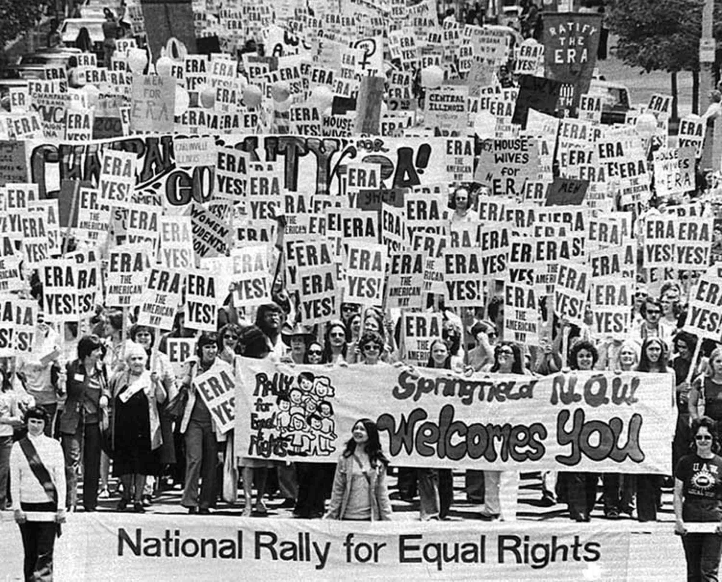 Many marchers holding signs that say "Era Yes!" and carrying a banner that says "National Rally for Equal Rights"