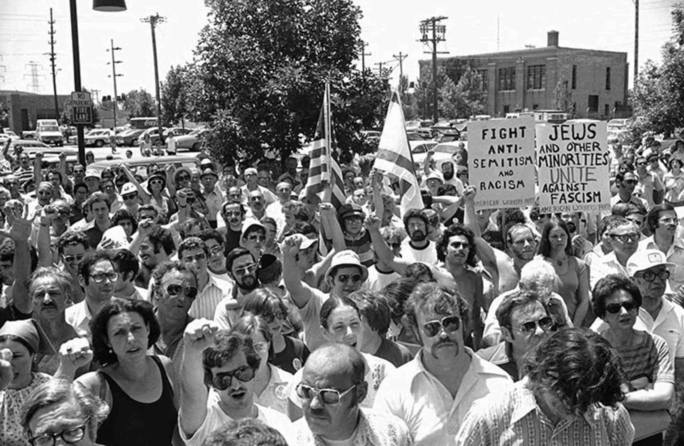 A black and white photo of a large group of people demonstrating, many with raised fists.