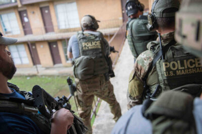 An image of 5 people holding police gear.