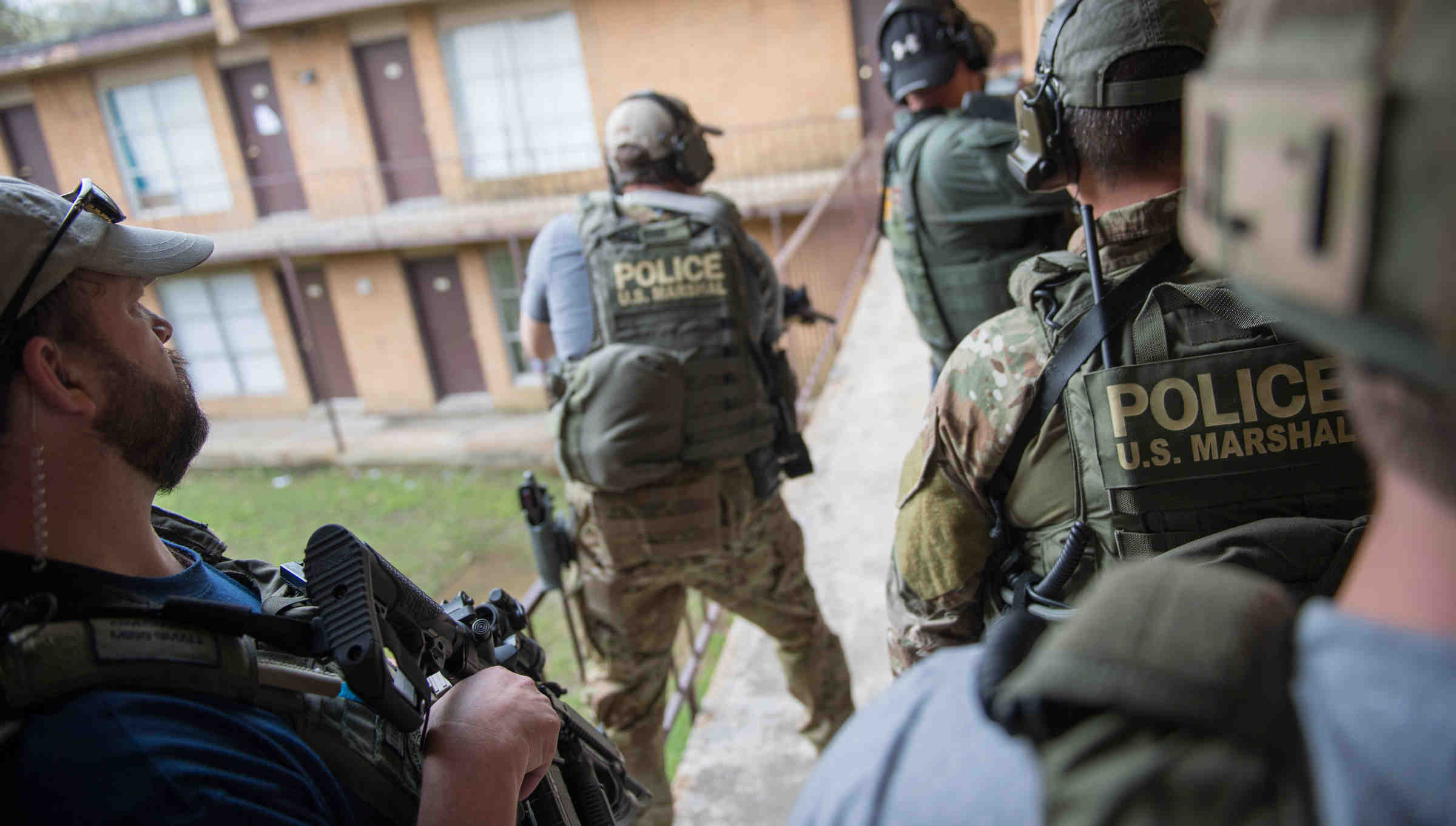 An image of 5 people holding police gear.