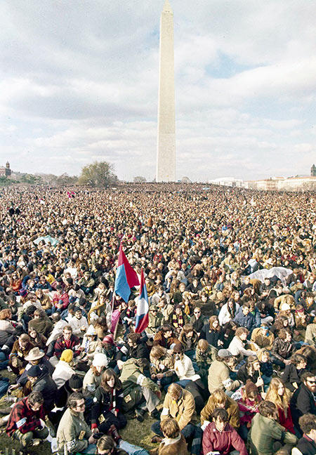 A large group of protestors with the Washington Monument in the background