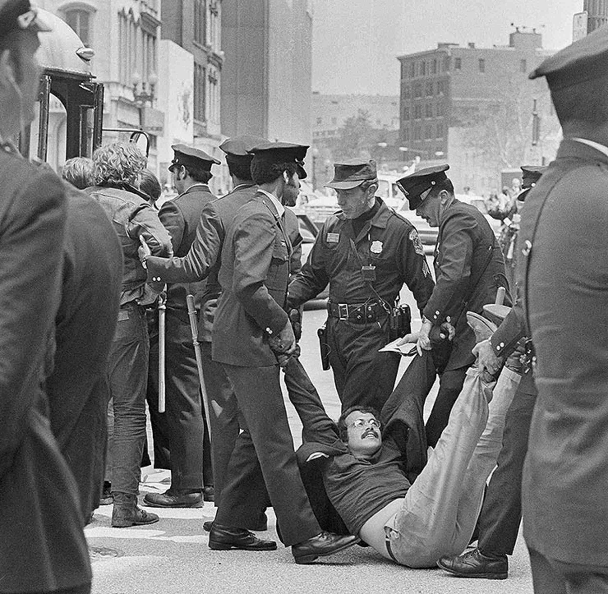 Multiple police officers dragging an anti-war demonstrator