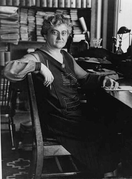 Rosika Schwimmer sitting in a library