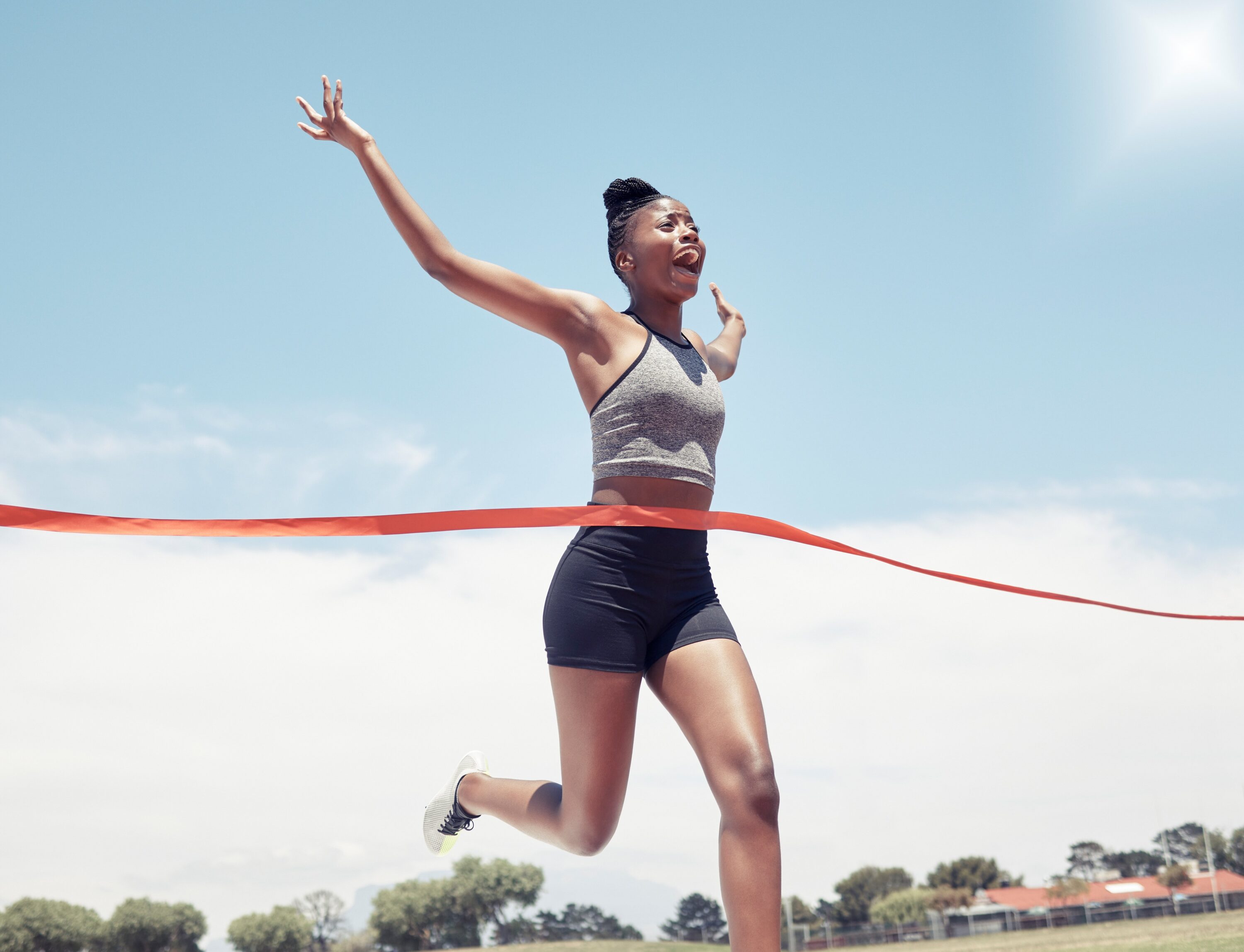 Black girl runner crossing the red victory ribbon