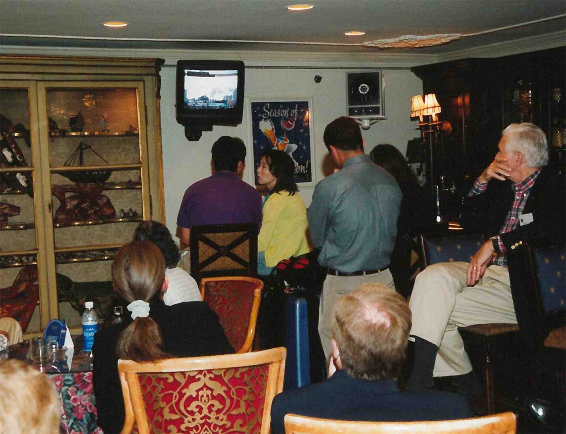 A group of people watching a small TV