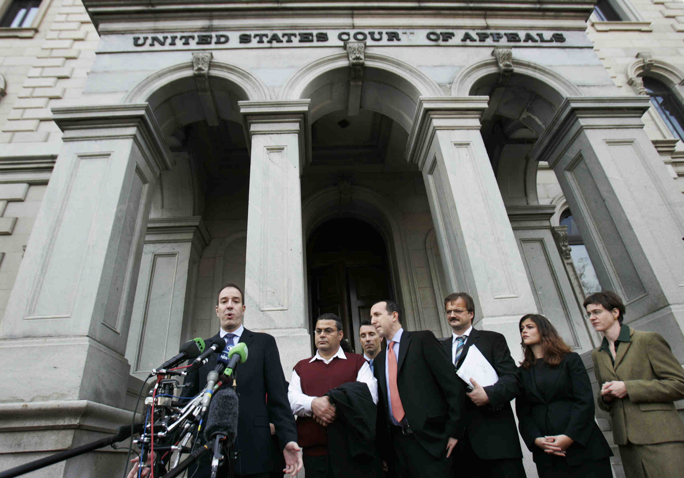 Anthony Romero speaking into many microphones on the steps of the US Court of Appeals