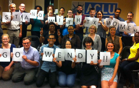 A photo of a group of people holding a sign that reads Stand With Texas Women, Go Wendy!