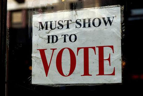 A sign in a window that reads: "MUST SHOW ID TO VOTE"