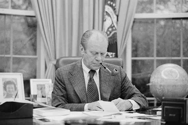 Gerald Ford looks at papers on his desk