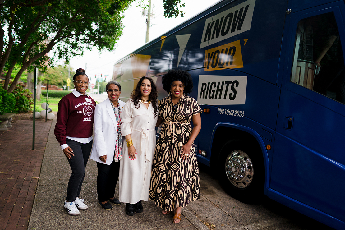 4 people posing in front of the "KNOW YOUR RIGHTS BUS."