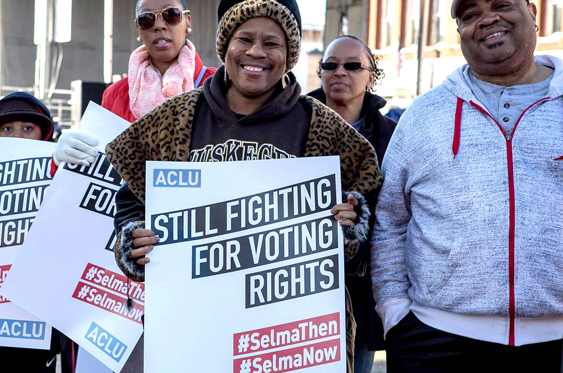 Activists holding ACLU signs that read: "STILL FIGHTING FOR VOTING RIGHTS"