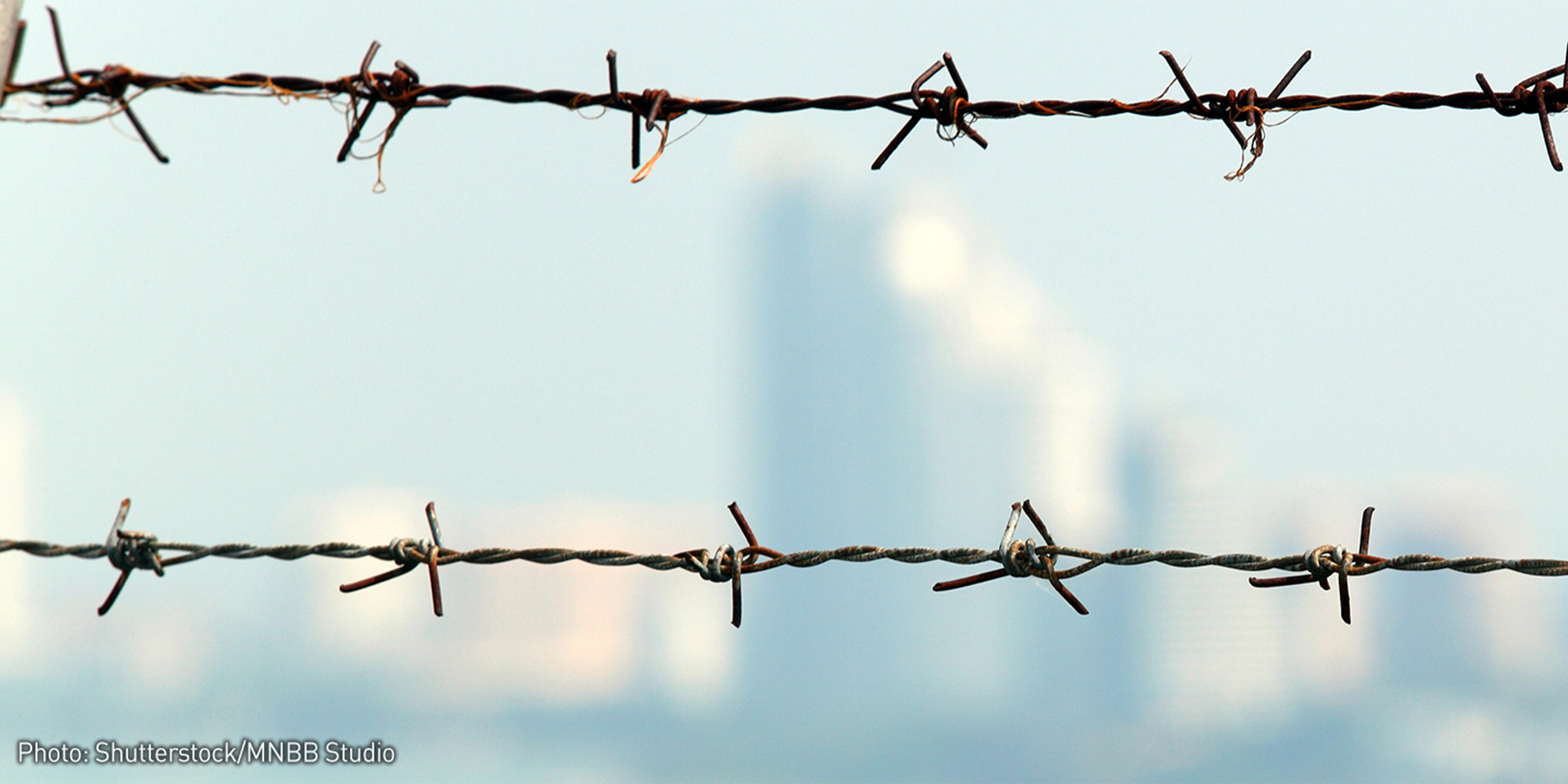 Barbed Wire Fence with City Scape in Background