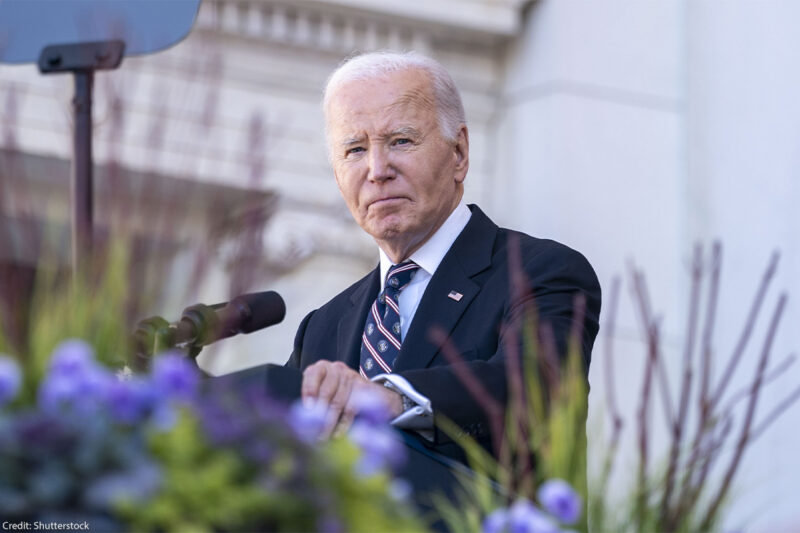 President Biden stares into the camera from behind a podium.