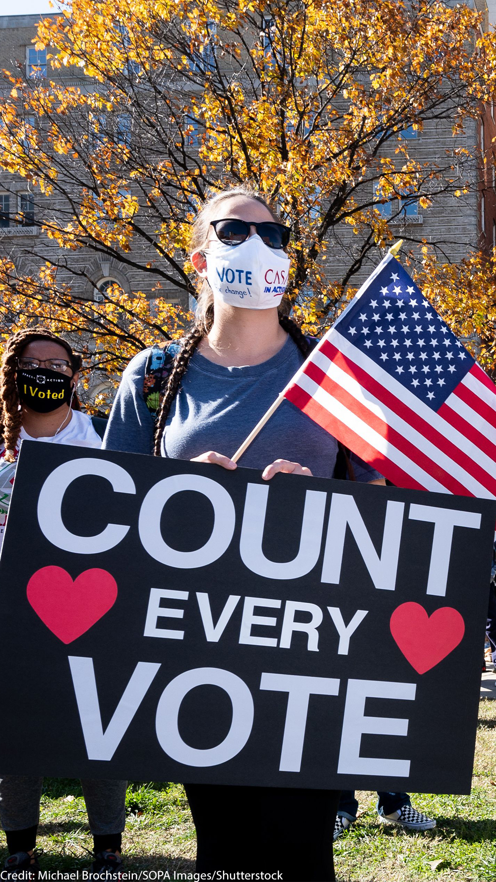 Two masked people hold signs that read "COUNT EVERY VOTE."