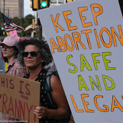 Demonstrators holding signs reading "KEEP ABORTION SAFE AND LEGAL" and "THIS IS TYRANNY".