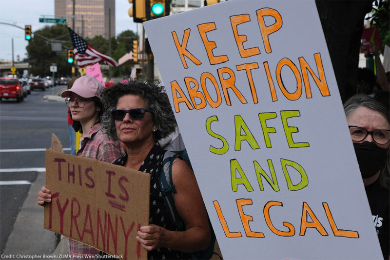 Demonstrators holding signs reading "KEEP ABORTION SAFE AND LEGAL" and "THIS IS TYRANNY".