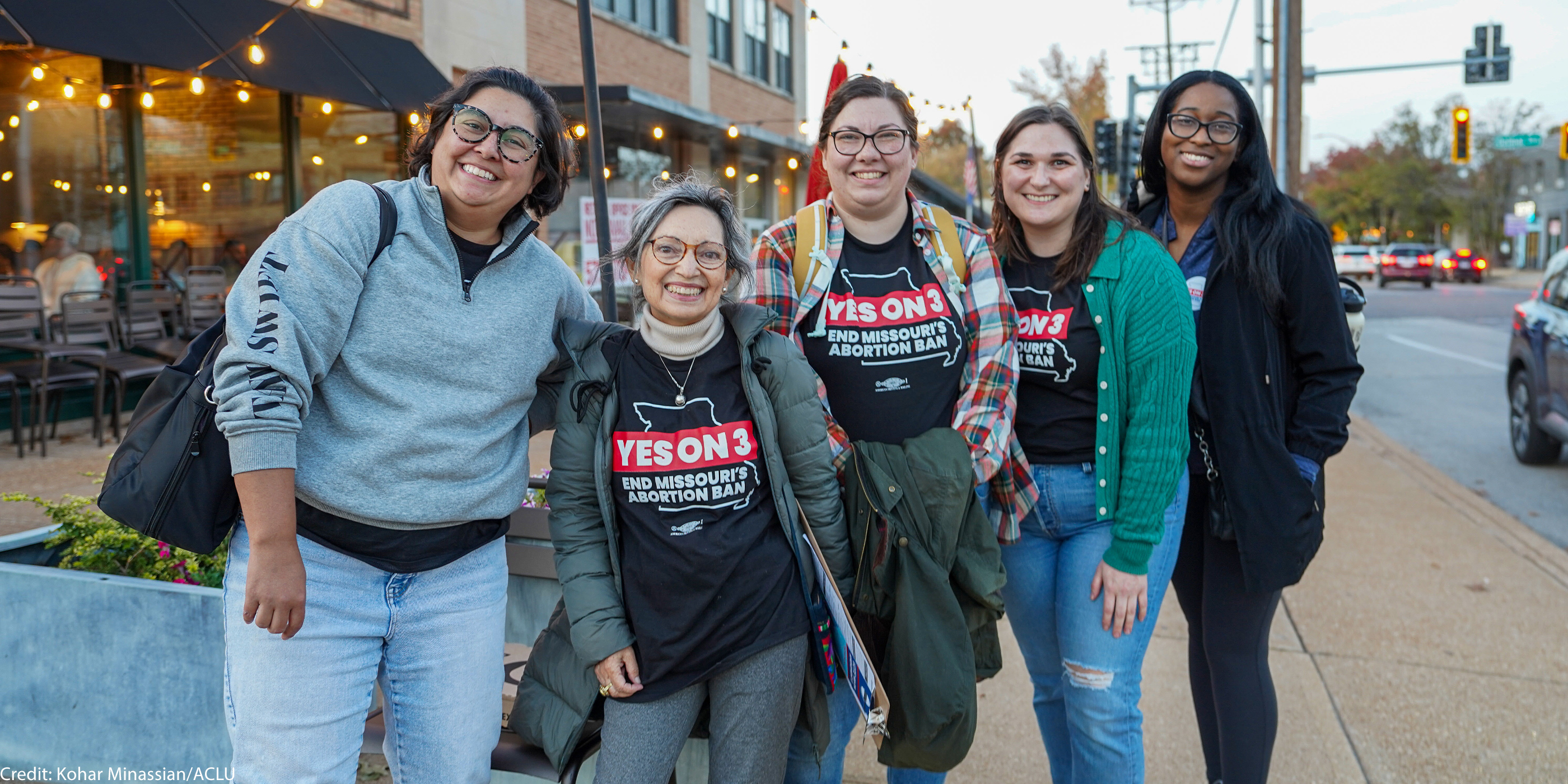 Four voting volunteers with three of them wearing t-shirts reading "YES ON 3"