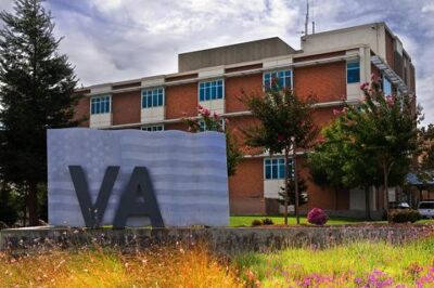 Brick Veterans' Affairs Medical Center building with sign shaped like the American flag