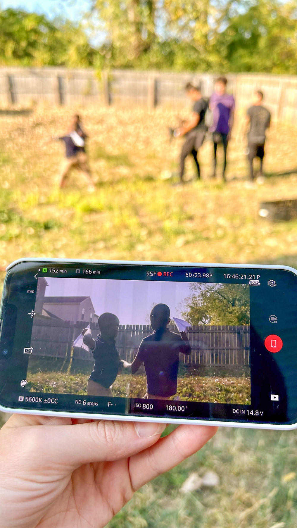 Children playing in a backyard behind the scenes for "The Long Road Home" article.