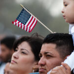 A girl and her father stand with some 200,000 immigrants' rights activists flood the National Mall to demand comprehensive immigration reform in Washington DC.