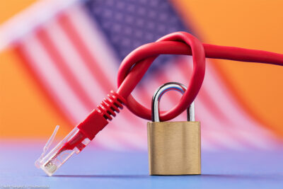 Closed padlock on a knotted network wire on the background of the American flag.