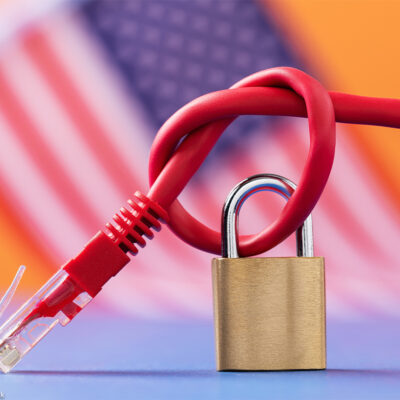 Closed padlock on a knotted network wire on the background of the American flag.