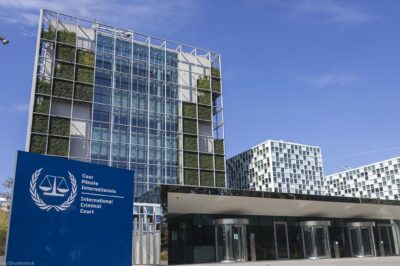 An exterior view of the International Criminal Court In The Hague, Netherlands, with the sign of with of the official logo and inscription of the International Criminal Court in the foreground.