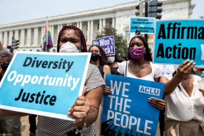 Protesters in front of the Supreme Court hold signs that read, "Diversity, Opportunity, Justice", "ACLU, WE THE PEOPLE", "Affirmative Action YES!" and "Asians for Affirmative Action".