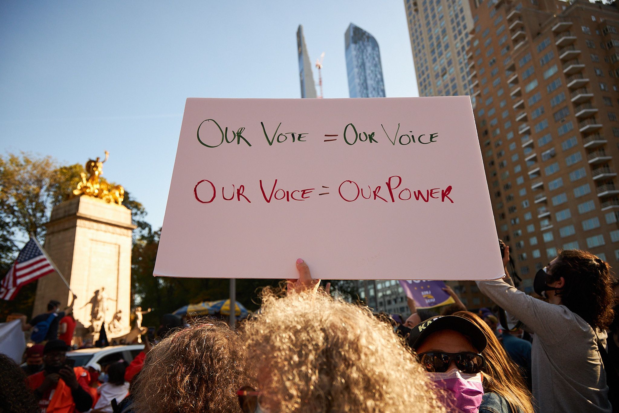 protesters holding up our vote our voice poster