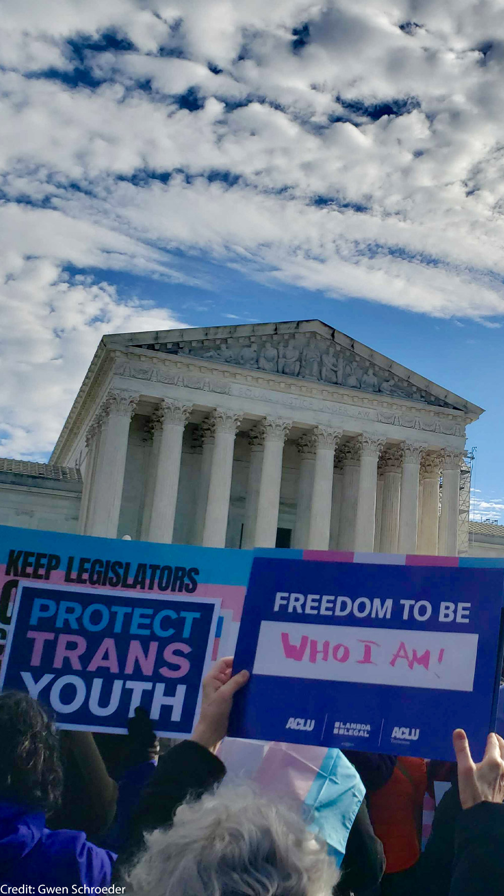 A group of individuals holding pro trans rights signs in front of the Supreme Court.
