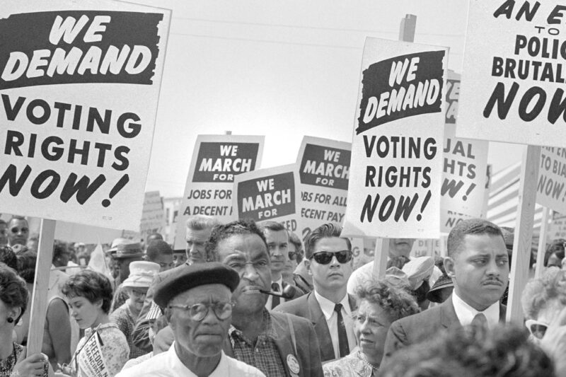 Protesters with signs at march on Washington, D.C. for Jobs and Freedom, carrying signs that read "WE DEMAND VOTING RIGHTS NOW!" and WE DEMAND AN END O POLICE BRUTALITY NOW!" on August 28, 1963.