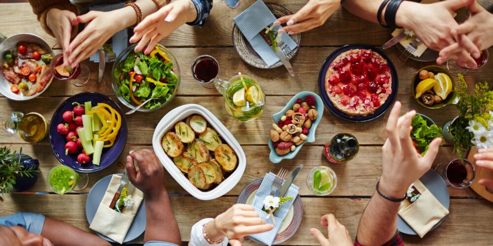 A group of people have an animated conversation over a dinner table.