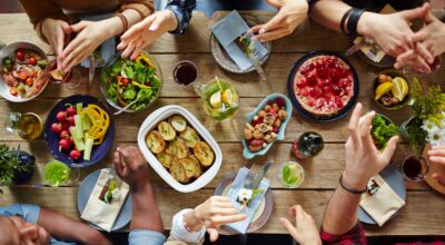 A group of people have an animated conversation over a dinner table.
