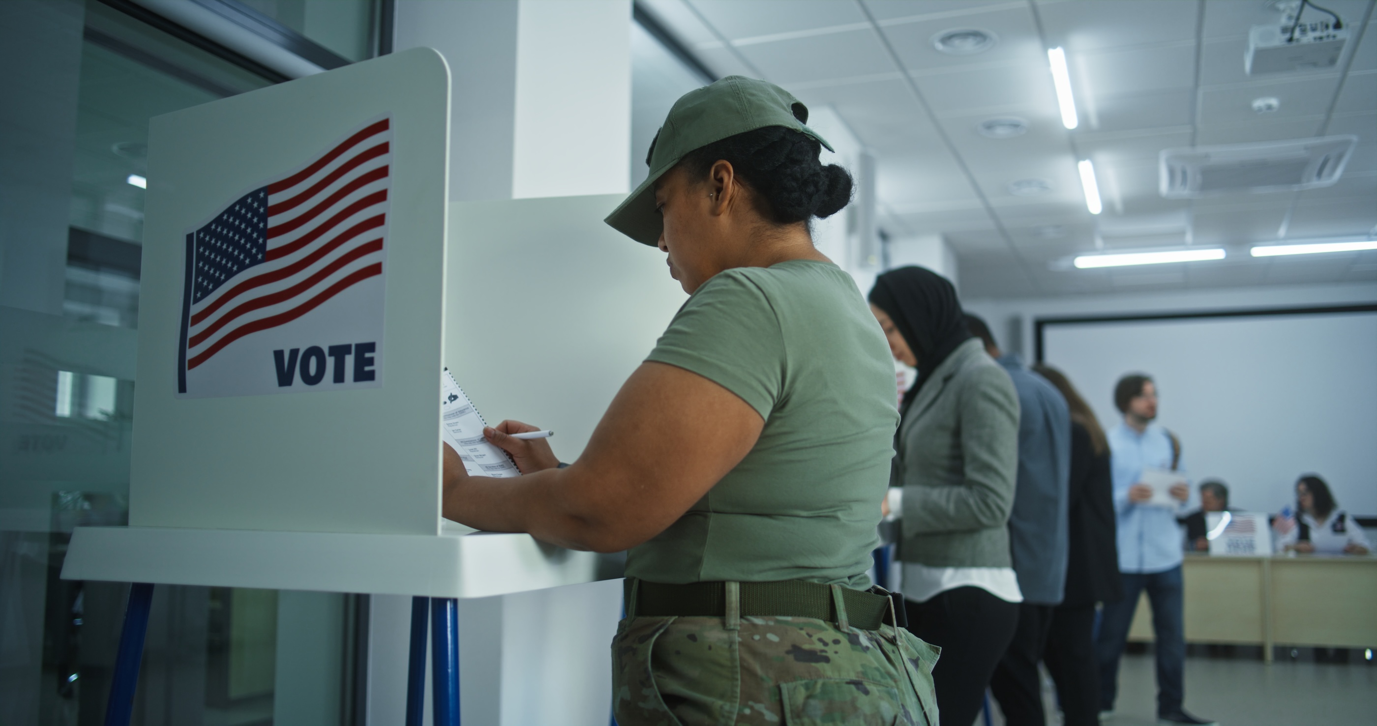 A servicemember in uniform votes.