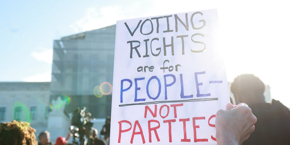 An individuals holding a sign saying "Voting Rights Are For People Not Parties," outside of the U.S. Supreme Court ahead of arguments in the Voting Rights case Callais v. Landry.