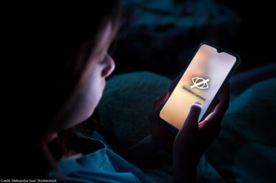 A child using smart phone in bed late at night.