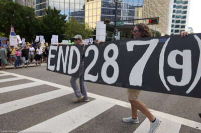 People in Florida carry a sign calling for an end to 287(g).